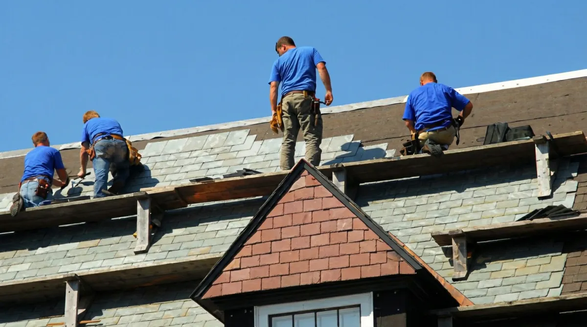 Roof replacement in progress with a team of professional contractors installing new shingles on a residential home in El Paso, TX